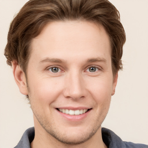 Joyful white young-adult male with short  brown hair and grey eyes