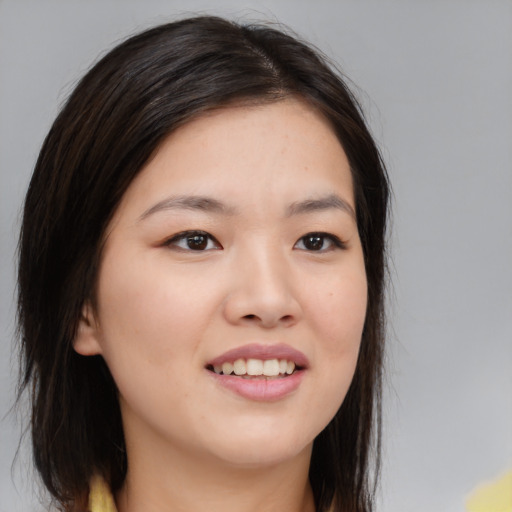 Joyful asian young-adult female with long  brown hair and brown eyes
