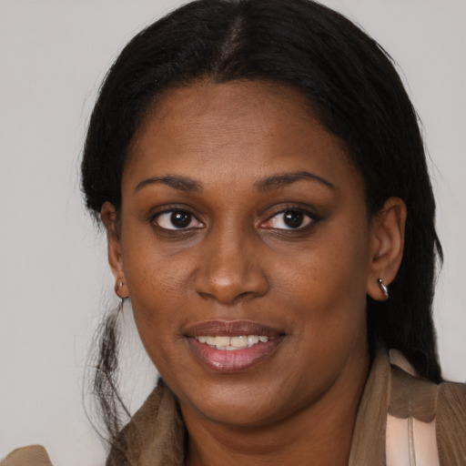 Joyful black adult female with long  brown hair and brown eyes