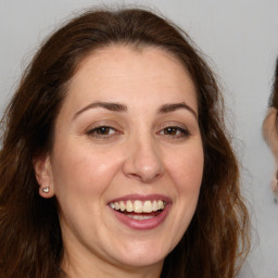 Joyful white adult female with long  brown hair and brown eyes