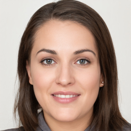 Joyful white young-adult female with long  brown hair and grey eyes