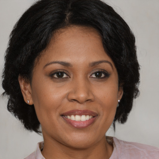 Joyful black young-adult female with medium  brown hair and brown eyes