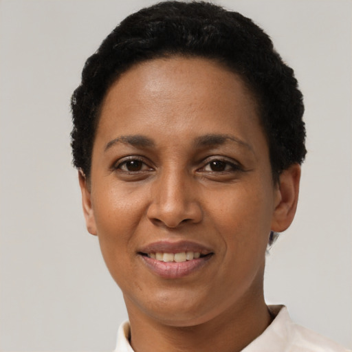 Joyful black adult female with short  black hair and brown eyes