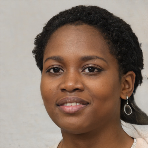 Joyful black young-adult female with medium  black hair and brown eyes