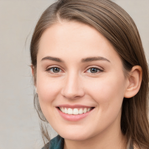 Joyful white young-adult female with long  brown hair and grey eyes