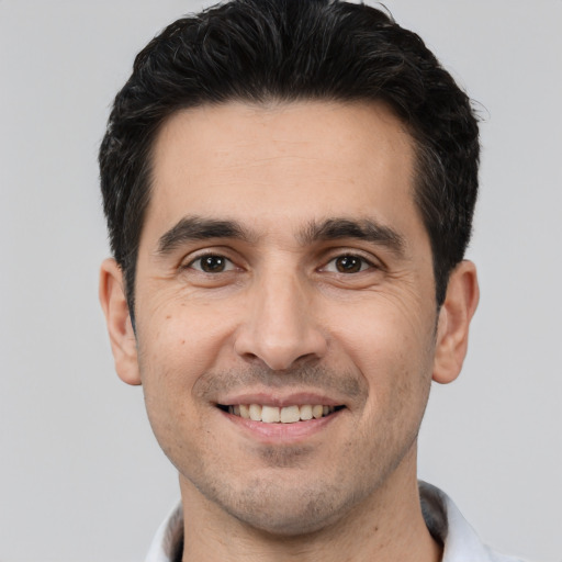 Joyful white young-adult male with short  black hair and brown eyes