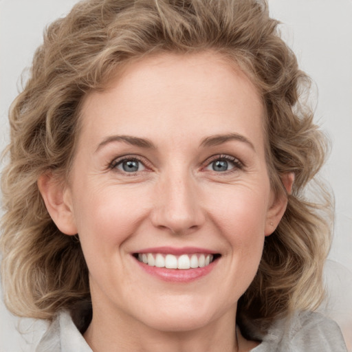 Joyful white young-adult female with medium  brown hair and blue eyes