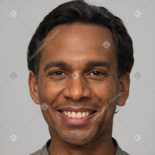 Joyful black adult male with short  black hair and brown eyes