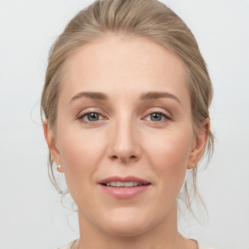 Joyful white young-adult female with medium  brown hair and grey eyes