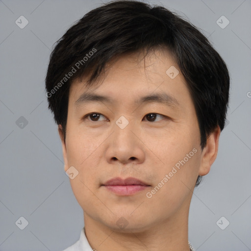 Joyful asian young-adult male with short  brown hair and brown eyes