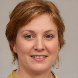 Joyful white adult female with medium  brown hair and blue eyes