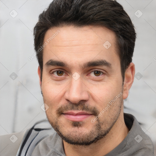 Joyful white adult male with short  black hair and brown eyes