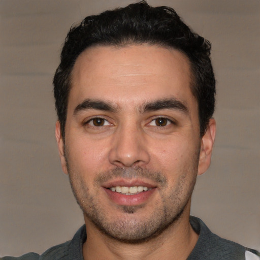 Joyful white young-adult male with short  black hair and brown eyes