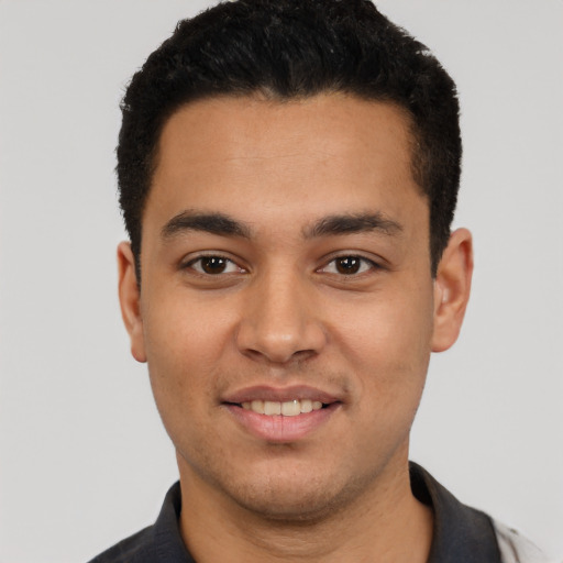 Joyful latino young-adult male with short  black hair and brown eyes