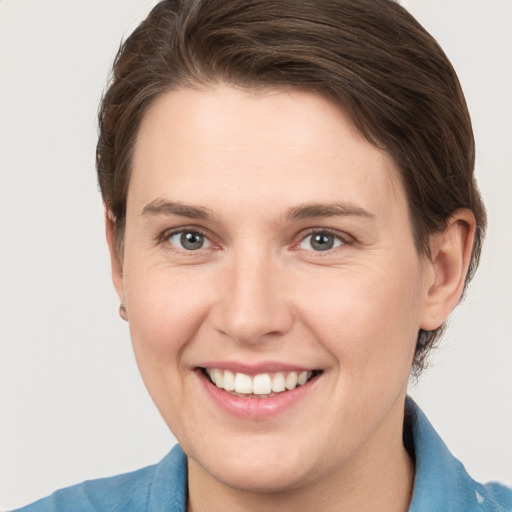 Joyful white young-adult female with short  brown hair and grey eyes