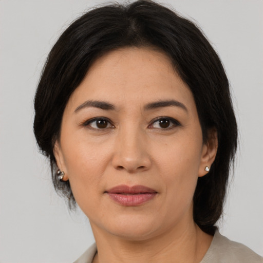 Joyful asian adult female with medium  brown hair and brown eyes