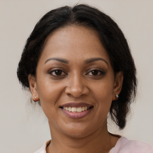 Joyful black adult female with medium  brown hair and brown eyes