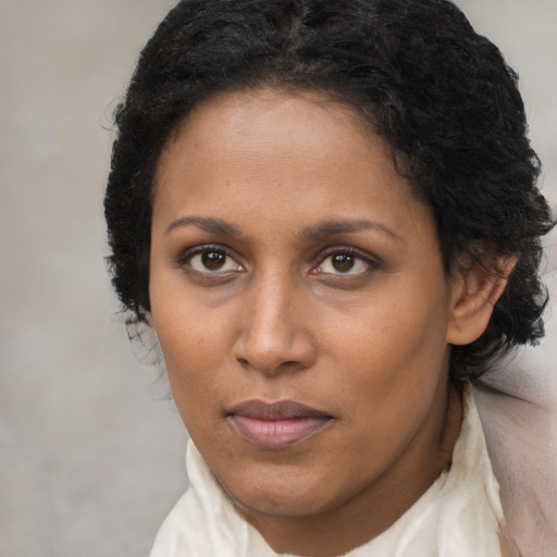 Joyful black adult female with short  brown hair and brown eyes