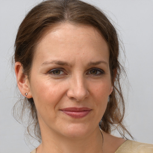 Joyful white adult female with medium  brown hair and grey eyes