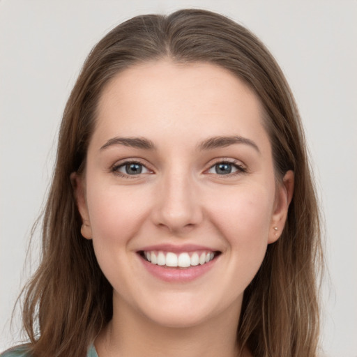 Joyful white young-adult female with long  brown hair and grey eyes