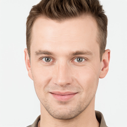 Joyful white young-adult male with short  brown hair and grey eyes