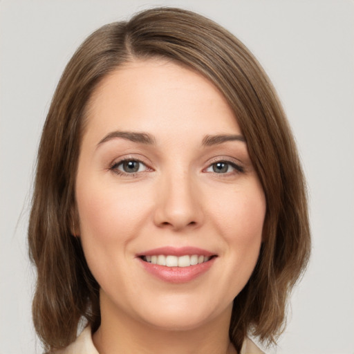 Joyful white young-adult female with medium  brown hair and green eyes