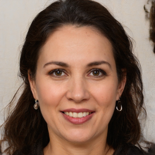 Joyful white adult female with long  brown hair and brown eyes
