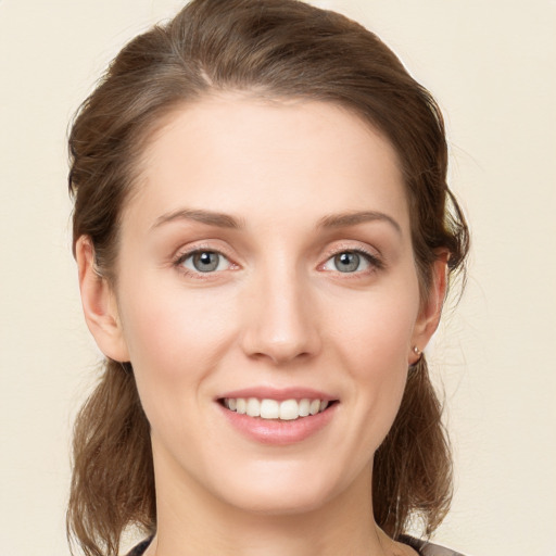 Joyful white young-adult female with medium  brown hair and green eyes