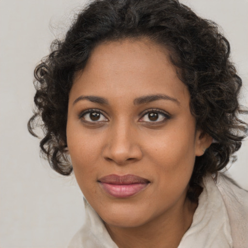 Joyful black young-adult female with long  brown hair and brown eyes