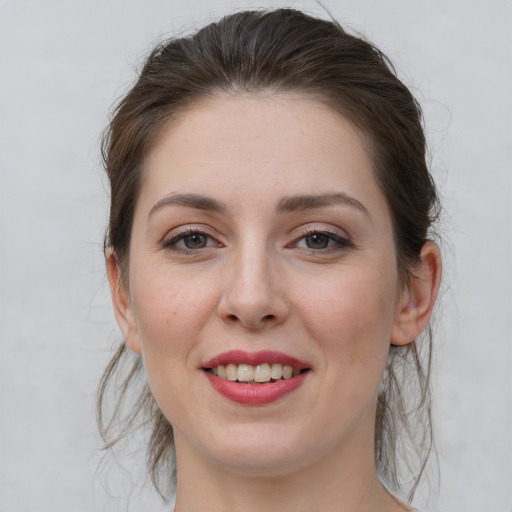 Joyful white young-adult female with medium  brown hair and grey eyes