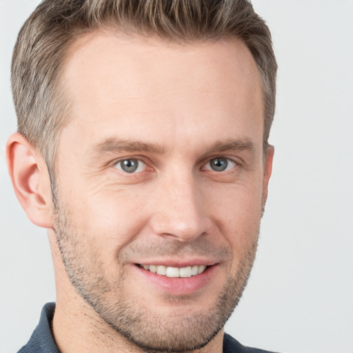 Joyful white adult male with short  brown hair and grey eyes