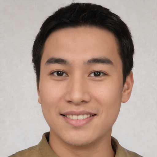 Joyful asian young-adult male with short  brown hair and brown eyes