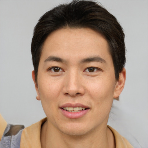 Joyful asian young-adult male with short  brown hair and brown eyes