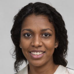 Joyful black young-adult female with medium  brown hair and brown eyes