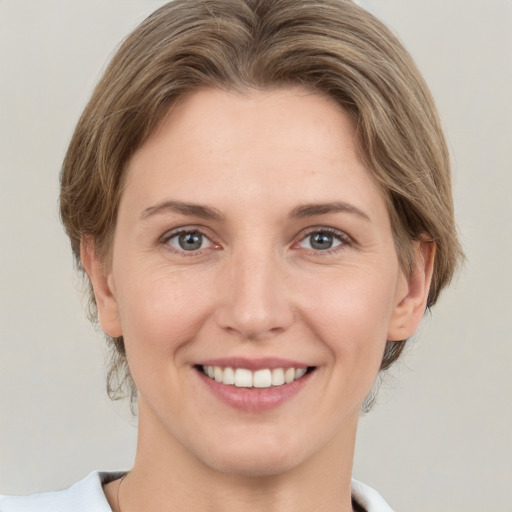 Joyful white young-adult female with medium  brown hair and grey eyes