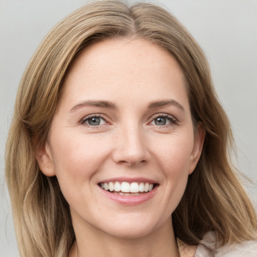 Joyful white young-adult female with medium  brown hair and green eyes