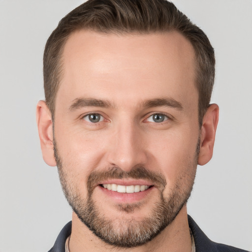 Joyful white young-adult male with short  brown hair and grey eyes