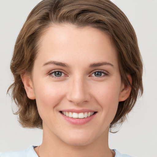 Joyful white young-adult female with medium  brown hair and green eyes