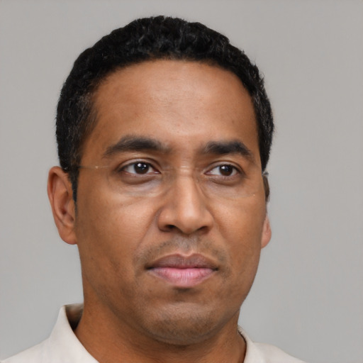 Joyful black adult male with short  black hair and brown eyes
