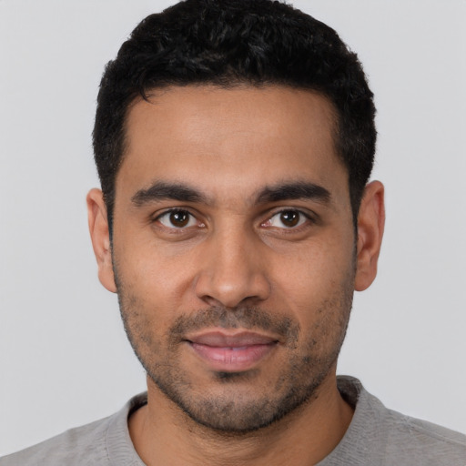 Joyful latino young-adult male with short  black hair and brown eyes