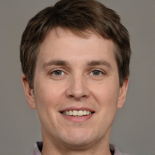 Joyful white adult male with short  brown hair and grey eyes