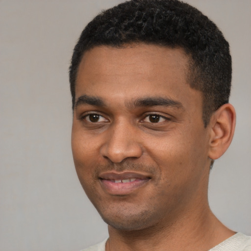 Joyful black young-adult male with short  black hair and brown eyes