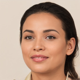 Joyful latino young-adult female with medium  brown hair and brown eyes