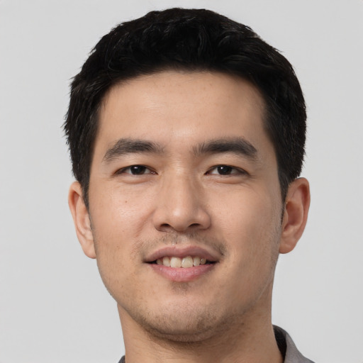 Joyful asian young-adult male with short  black hair and brown eyes