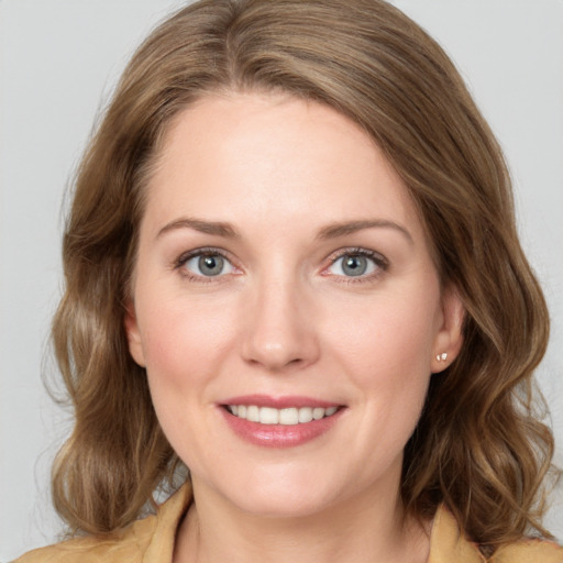 Joyful white young-adult female with medium  brown hair and blue eyes