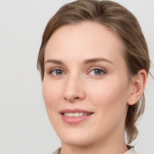 Joyful white young-adult female with medium  brown hair and blue eyes