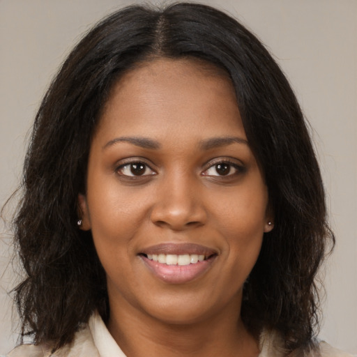 Joyful black young-adult female with medium  brown hair and brown eyes