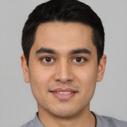 Joyful latino young-adult male with short  black hair and brown eyes