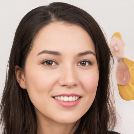 Joyful white young-adult female with long  brown hair and brown eyes