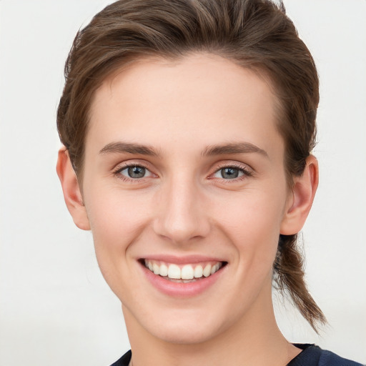 Joyful white young-adult female with medium  brown hair and blue eyes